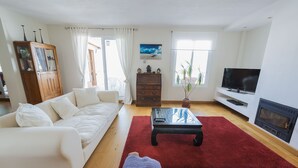 A living room with a sofa, a coffee table, a TV, and a fireplace. - Beautiful large 3 bedroom apartment, terrace sea views, Wifi. (Tarifa)
