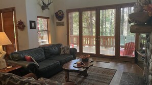A spacious living room with a leather couch, a coffee table, and a fireplace. -  Pinetop CClub, AC, 2 Bd Rm Plus Loft, Huge Windows, Enclosed Deck, 1/2 Acre, (Pinetop)
