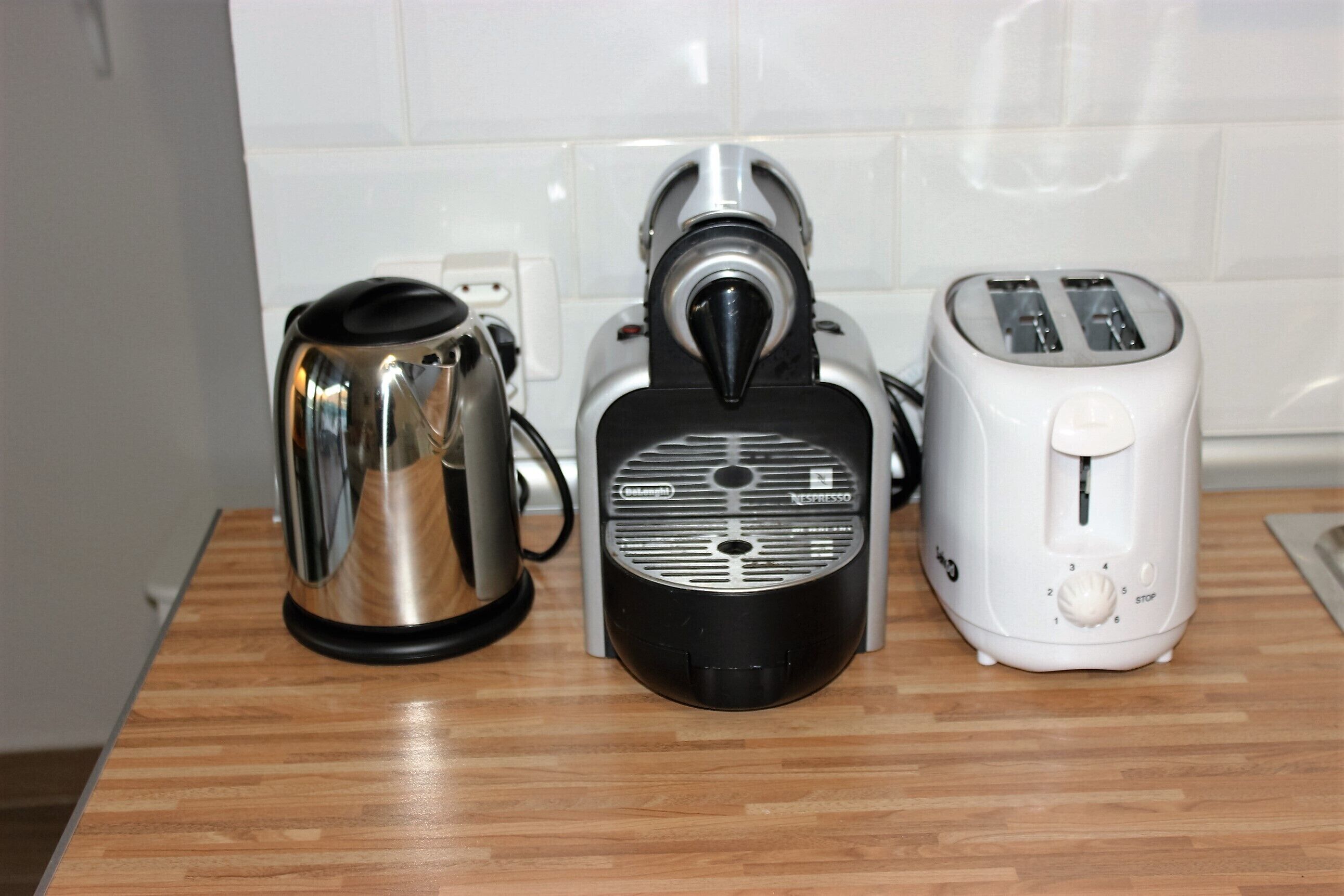 Un plan de travail de cuisine avec une machine à café, un appareil à expresso noir et un grille-pain blanc.