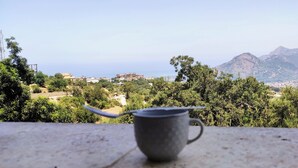 A metal cup on a ledge with a view of a mountainous landscape and buildings in the distance. - Superb F3 Apartment with Sea & Mountain View (Souk El Ténine)