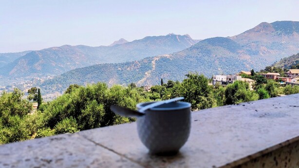 A view from a balcony overlooking a mountainous landscape with buildings in the distance. - Superb F3 Apartment with Sea & Mountain View (Souk El Ténine)