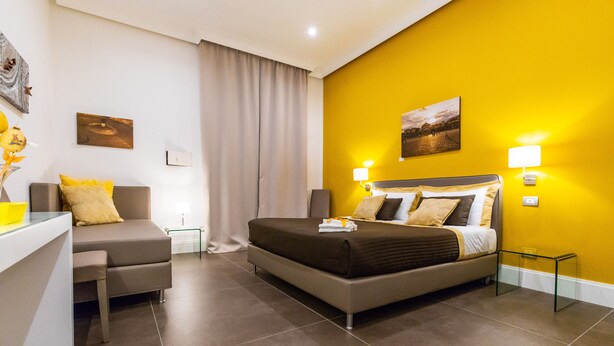 A modern hotel room with a bed, a desk, and a sofa. - n'apARTment - art in the heart of Naples (Napoli)