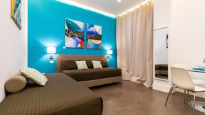 A bedroom with a bed, a sofa, a desk, and two wall-mounted lamps. - n'apARTment - art in the heart of Naples (Napoli)
