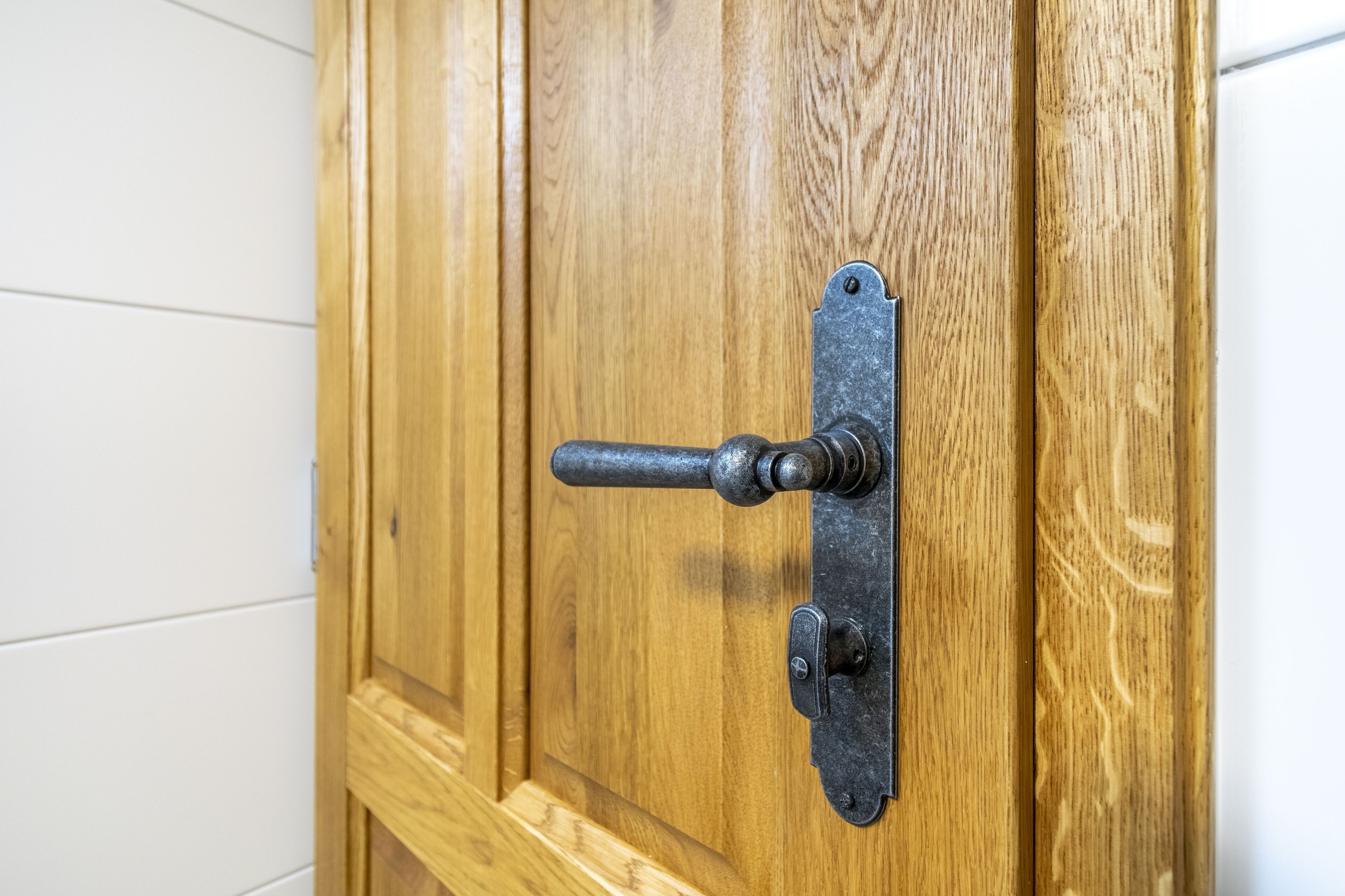 A wooden door with a metal handle and latch.