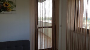 Una habitación con una puerta corredera, un sofá y un cuadro en la pared.