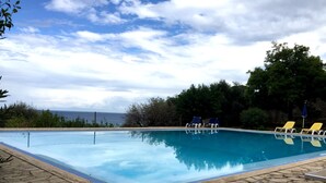 A swimming pool with a stone deck, surrounded by trees and a view of the sea. - The Tower & La Torretta by the Sea-Villa Palamara 1868 (Cefalù)