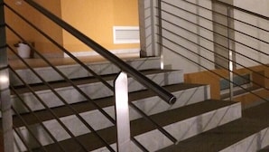 Un escalier avec des rampes en métal et un sol en marbre.