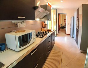 Enjoy cooking in this well-lit kitchen with a gas stove, microwave, oven, and refrigerator.