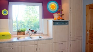 A kitchen with a window, a sink, cabinets, and a dish rack. - Morning sun vacation apartment in a country house with a magnificent garden  (Westerstede)