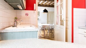 Une cuisine équipée d’un évier, d’un plan de travail et d’un coin repas avec des chaises.