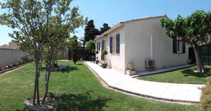 Un bâtiment d’un seul étage, doté d’un toit plat, d’une allée pavée et d’une pelouse bien entretenue.
