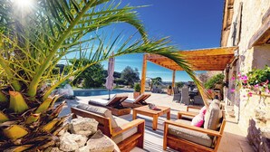 A patio area with outdoor furniture, a pergola, and a view of the sea. - Casa Guillarmou - Heated Pool & Spa - Splendid (Castelnau-de-Montmiral)