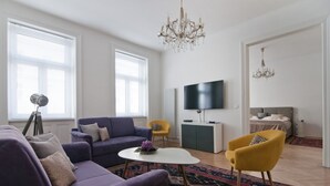Una sala de estar moderna con un sofá púrpura, un sillón amarillo y una mesa de centro blanca.