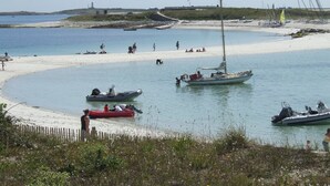 A beach with boats, a sandy shore, and a lighthouse in the background. - House in a pastoral setting: 2 or 4 people (Douarnenez)