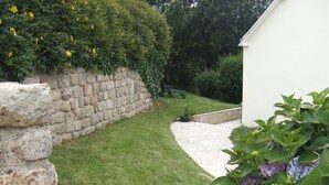 A stone wall, a grassy lawn, and a pathway leading to a building. - House in a pastoral setting: 2 or 4 people (Douarnenez)
