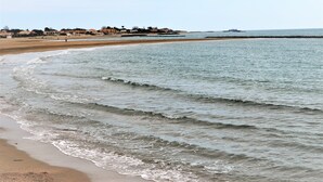 A beach with waves, a distant shoreline with buildings, and a pier. - Village apartment  (Agde)