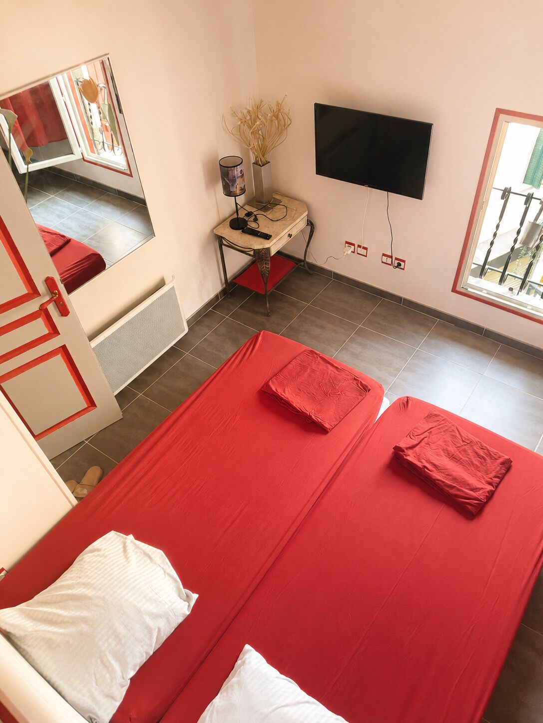 A room with a bed, a desk, a TV, and a window.