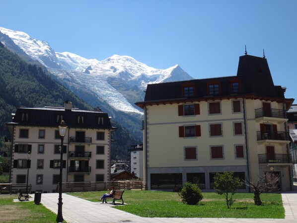 A building with a balcony and a view of snow-capped mountains.