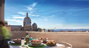 A table with food and a bottle, overlooking a historic building with domes. - BASKET 38+ 10m2 terrace facing the sea and Major / 4 PLACES 300mMUCEM, 800mVIEUX-PORT (Marseille)