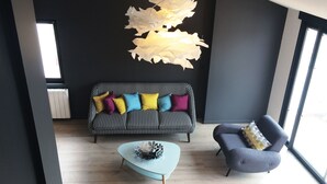 A modern living room with a black and white patterned sofa, a light blue coffee table, and a gray armchair. - BASKET 38+ 10m2 terrace facing the sea and Major / 4 PLACES 300mMUCEM, 800mVIEUX-PORT (Marseille)