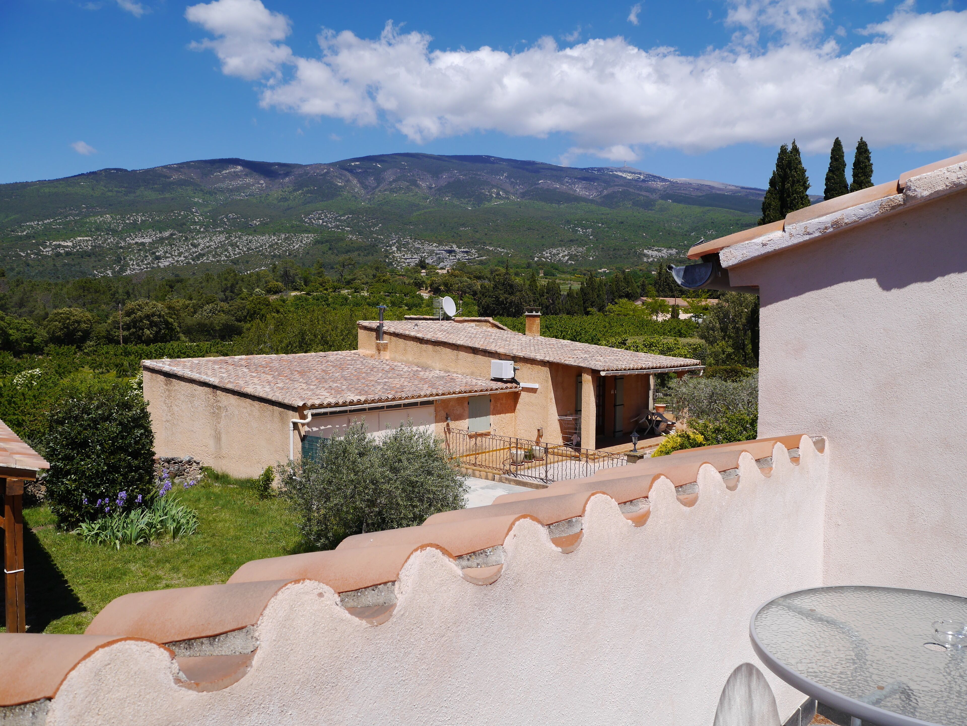 A villa with a terrace overlooking a mountainous landscape.