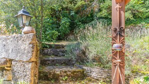 Un escalier en pierre mène à une structure en bois sur laquelle est posée une lanterne, sur le côté gauche.