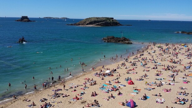 A crowded beach with clear blue water, rocky outcrops, and boats in the distance. - Proche Plage & remparts, T1bis, terrace, Wifi, parking space, bed made (Saint-Malo)
