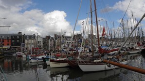 A marina with multiple boats docked, surrounded by buildings with various architectural styles. - Large home park, in a small Breton village 4 km from the sea  (Kerfot)
