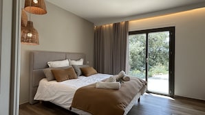 Een moderne slaapkamer met een groot bed, uitzicht door een schuifdeur en een plafondlamp.