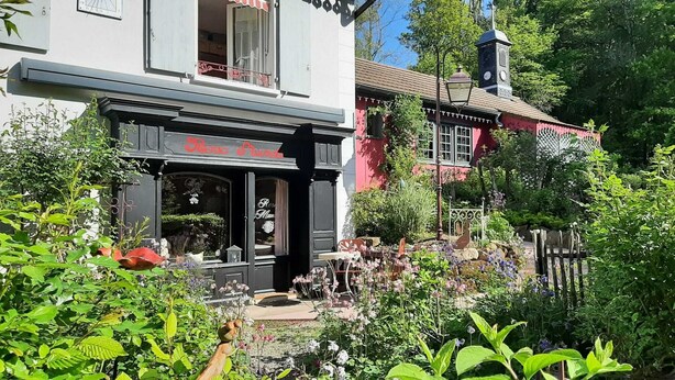 A traditional building with a black awning and a sign that reads "Rosenstrasse." - A cottage in a garden in Rougegoutte (Rougegoutte)