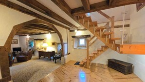 A rustic interior with a wooden staircase, stone walls, and a cozy seating area with a lamp. - Cottage of charm and character, 220 m2, quiet, between Sarlat and Lascaux. (Archignac)