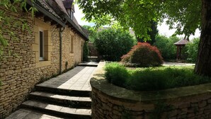 A stone building with a stone staircase leading to a gated entrance. - Cottage of charm and character, 220 m2, quiet, between Sarlat and Lascaux. (Archignac)