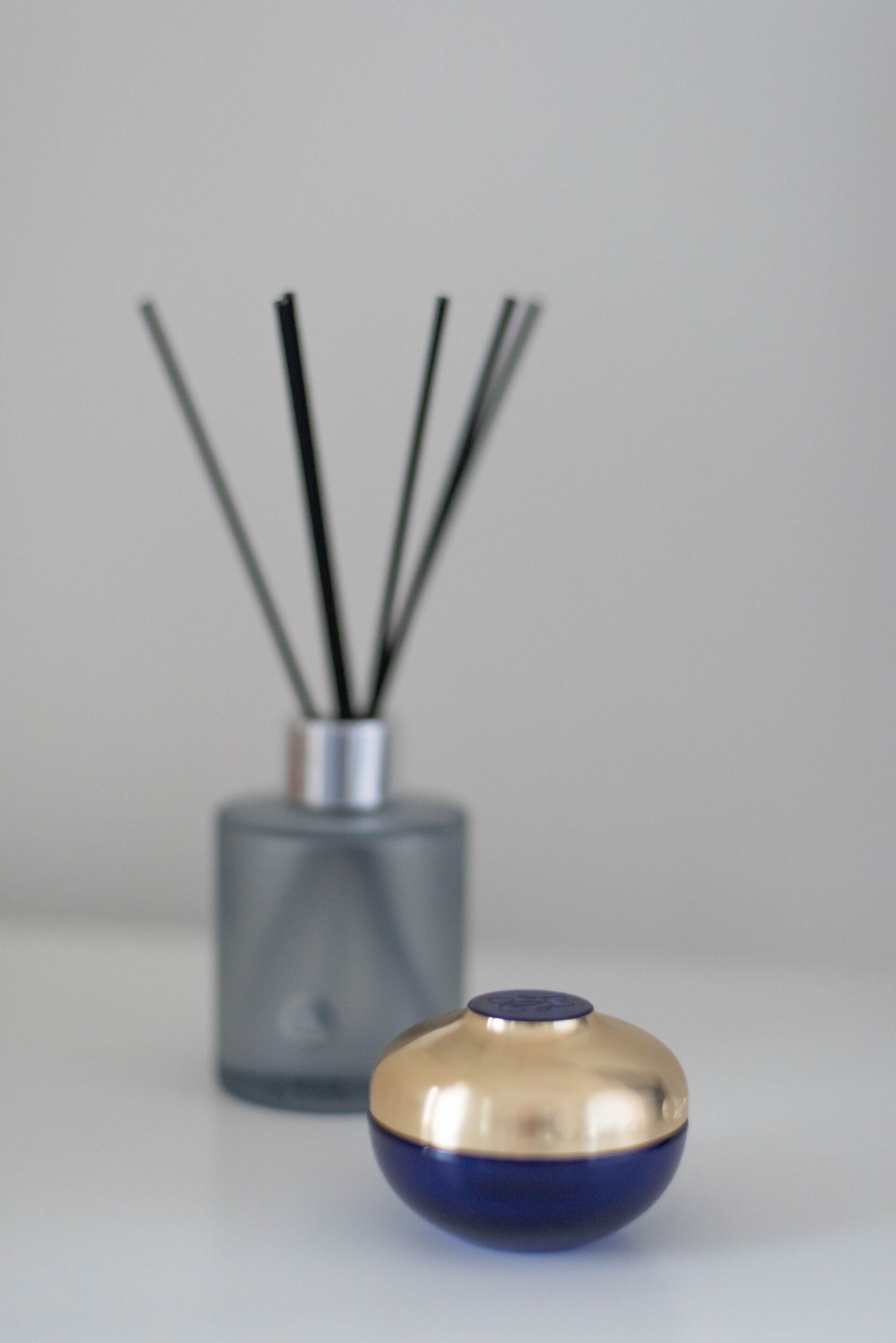 A small, metallic bowl with a blue base and a gold top, placed on a white surface.