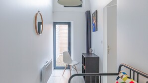 Un dormitorio con cama, escritorio y silla. Hay una ventana con vista al exterior.