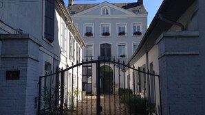 Un patio amurallado con un edificio blanco que tiene múltiples ventanas y jardineras.