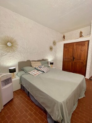 A bedroom with a bed, two bedside tables, a heater, a wardrobe, and decorative wall sconces. - Space, sun and freedom: 4 terraces, private garden, air-conditioned rooms.  (Propriano)
