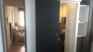 A bedroom with a bed, a wardrobe, and a bathroom visible through an open door. - T2 ground floor,  air conditioning placed in February 2023:)free public car park (Perpignan)