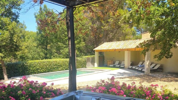 Un jacuzzi con vista despejada del jardín circundante y la zona de la piscina.