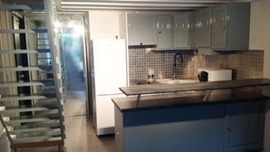 A modern kitchen with a built-in island, white cabinets, and a stainless steel refrigerator. - A cozy little nest in Biscarosse Lac, Superb high-end full option duplex (Biscarrosse)