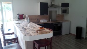 A compact kitchen with a wooden countertop, a built-in oven, and a microwave.