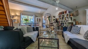 A living room with two sofas, a coffee table, and a bookshelf filled with books and decorative items.