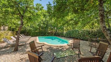 Een buitenzwembad en ligstoelen