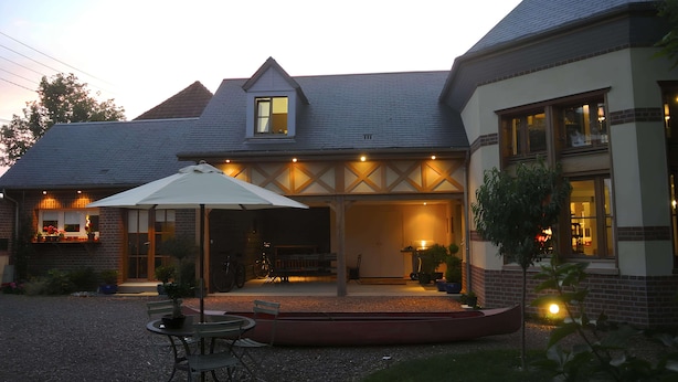 Ein Haus mit überdachter Terrasse, Essbereich und kleinem Garten.