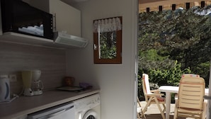 Una cocina funcional con lavadora, microondas y cafetera.