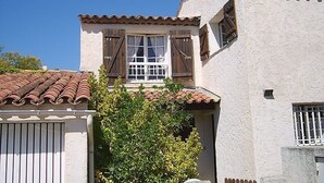 A two-story building with a tiled roof, white walls, and wooden shutters on the windows. - Townhouse ,, 3 + 1 bedrooms, 2. 5 bathrooms, air conditioning, wifi PRICE REDUCED (Fréjus)