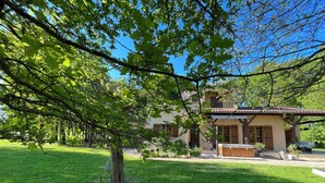 A house with a garden, a patio, and a covered outdoor seating area. - Gîte with SPA in a large park in the heart of Périgord ( Monpazier-Dordogne) (Capdrot)