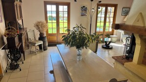 A spacious kitchen with a long table, wooden cabinets, and a view of the garden through the windows. - Gîte with SPA in a large park in the heart of Périgord ( Monpazier-Dordogne) (Capdrot)