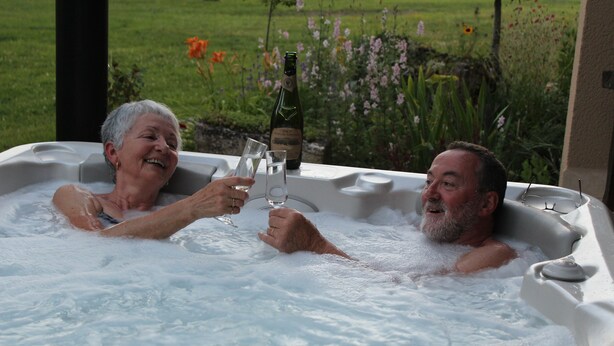 A hot tub with two people toasting with champagne glasses. - Gîte with SPA in a large park in the heart of Périgord ( Monpazier-Dordogne) (Capdrot)