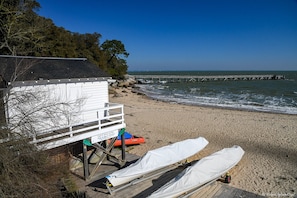 A beach with a lifeguard station, a pier, and a lifeguard chair.