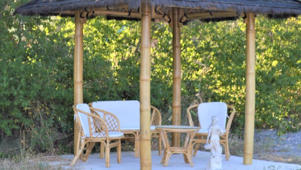 A bamboo gazebo with white wicker furniture, surrounded by greenery. - Luxury 200m² villa with private pool, Clevacances label (3 keys) (Saint-Clément)